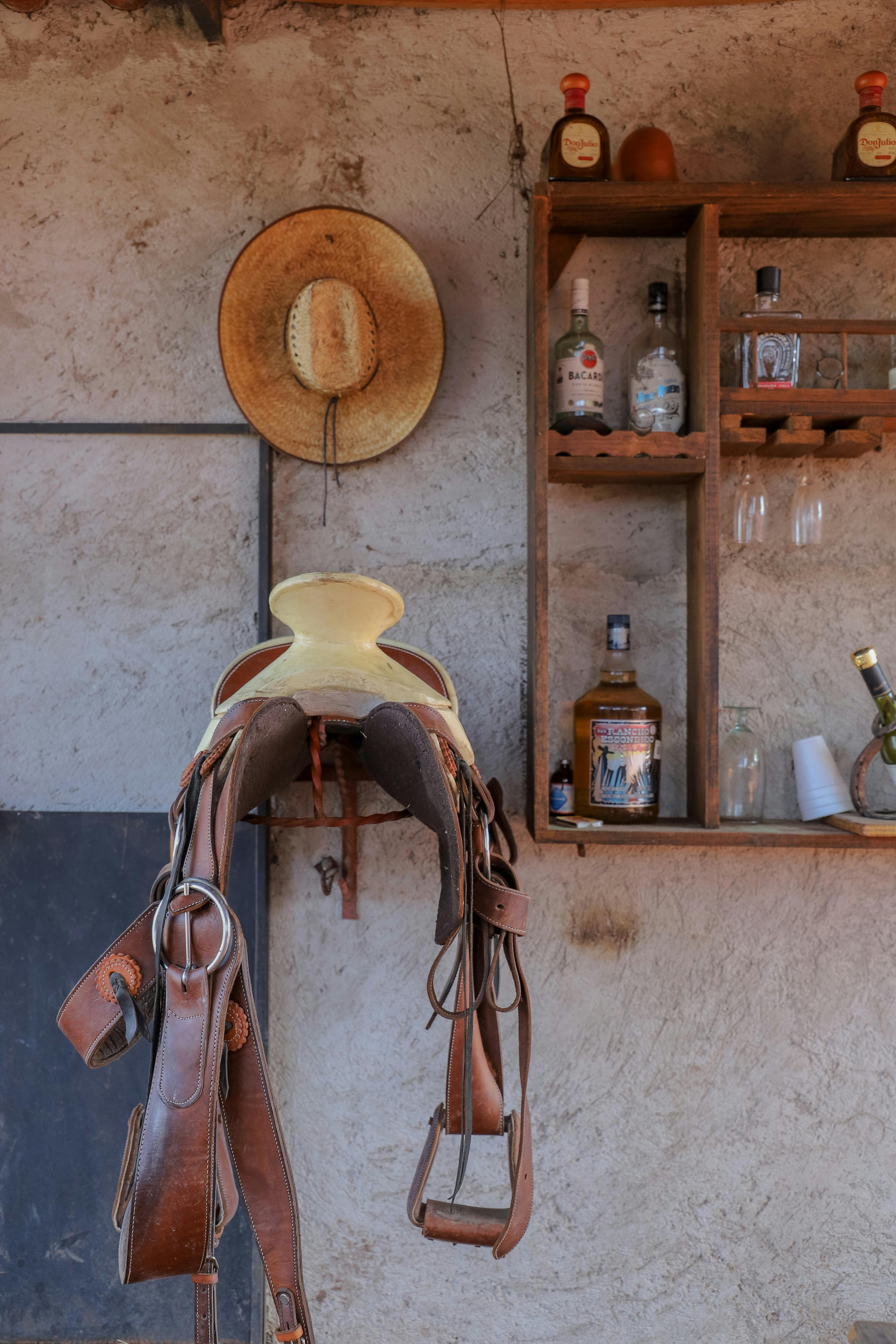 saddle and hat hung by stables